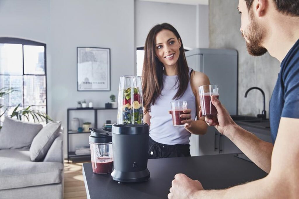 Man and woman enjoying glasses of a berry smoothie made with our Swan Stealth Personal Blender