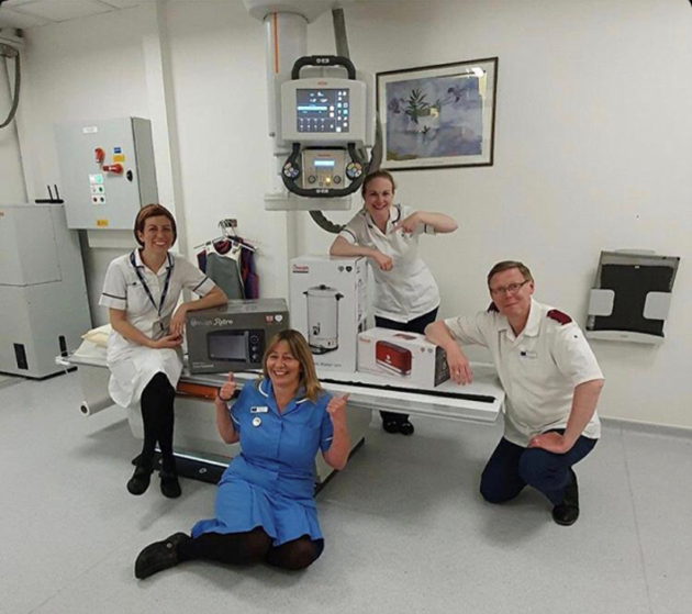 Four nurses gathered around a medical machine smiling with their swan products
