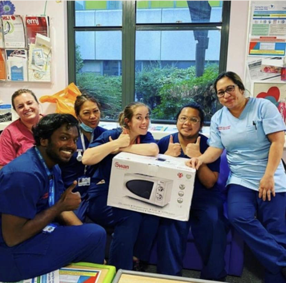 A group of nurses holding a swan microwave