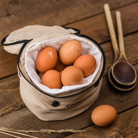 Photograph of a bag of eggs next to some wooden spoons