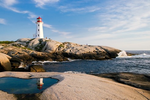 Photograph of a lighthouse and rock pools next to the ocean