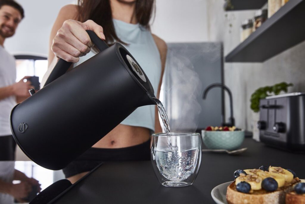 Photograph of woman pouring boiling water from the Swan Stealth Kettle