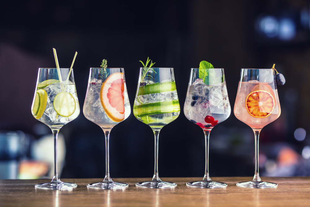 Image of 5 colourful cocktails lined up on a table