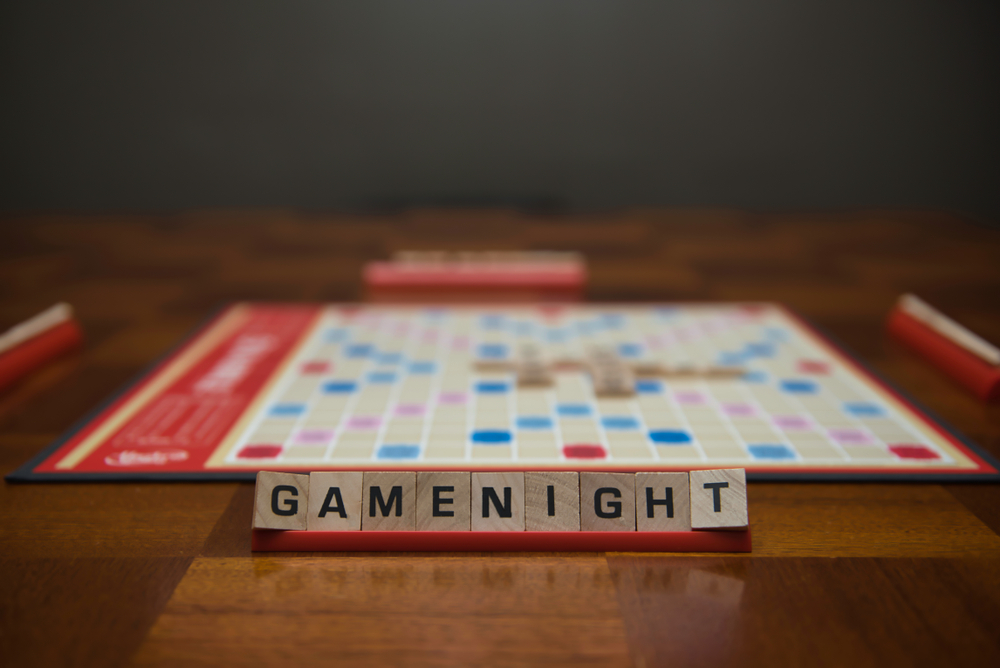 Image of a scrabble board with the tiles spelling game night