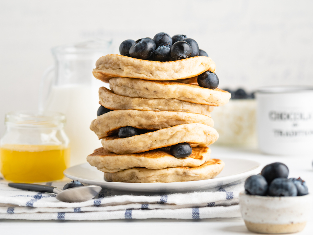 Image of a stack of fluffy pancakes with blueberries on top