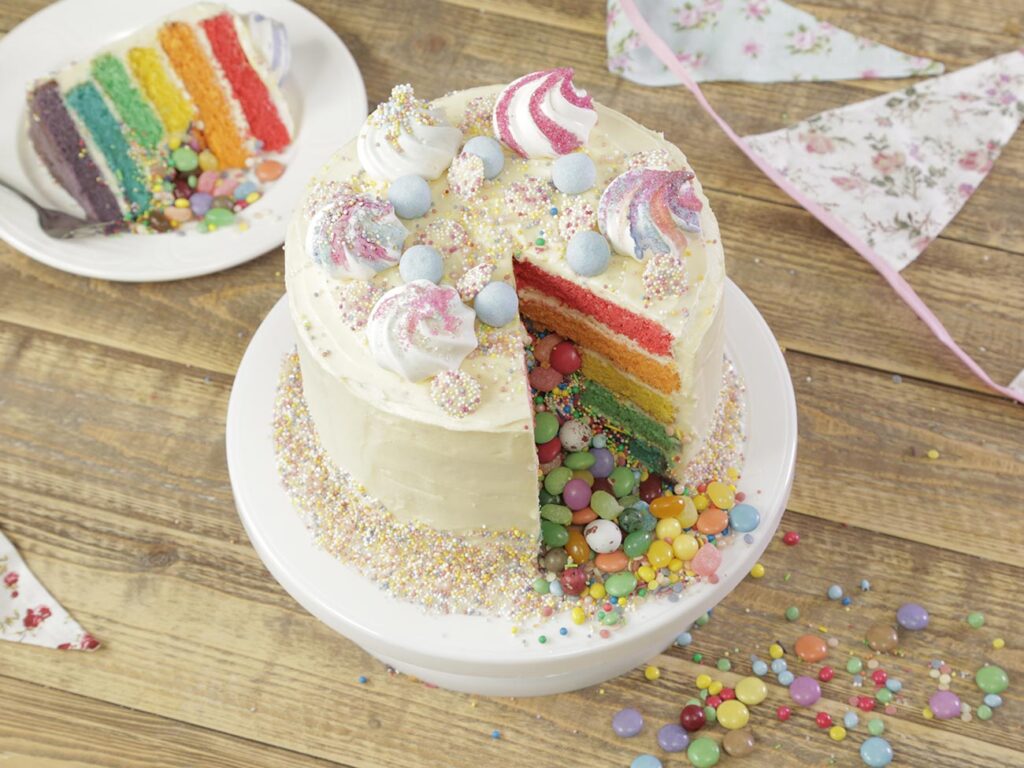 Birthday cake with sprinkles on a wooden table