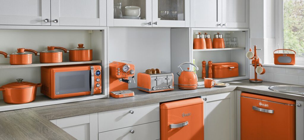 Kitchen fitted with Swan Retro Orange appliances including Retro Microwave, Retro Pans, Retro Espresso Machine, Retro Toaster and Retro Fridge