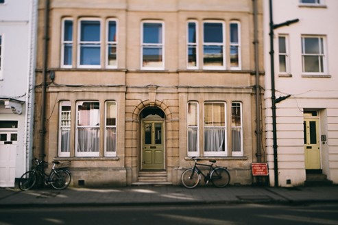 Photograph of a cream coloured-house in Oxfordshire with bikes parked outside