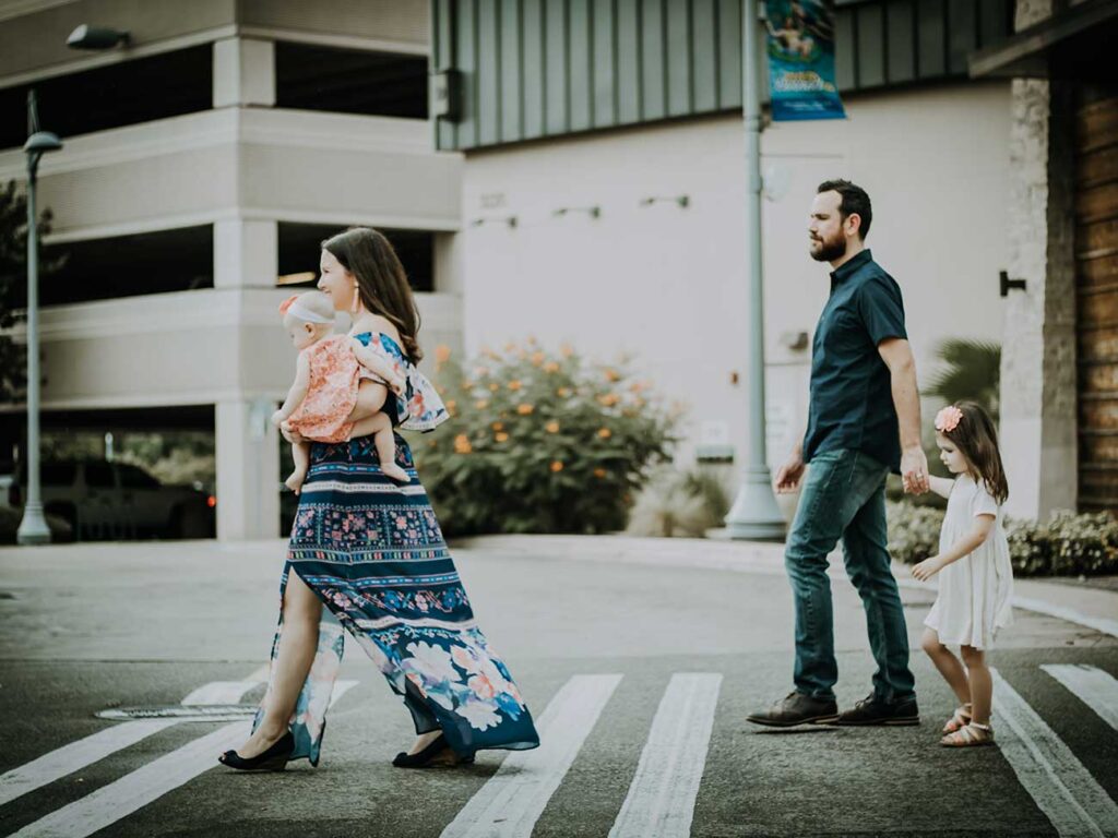 Photograph of a mother, father and their two children walking across a zebra crossing