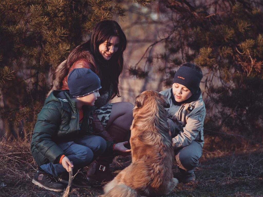 Photograph of a mother, her two sons and their dog on a walk in the woods during Easter holiday