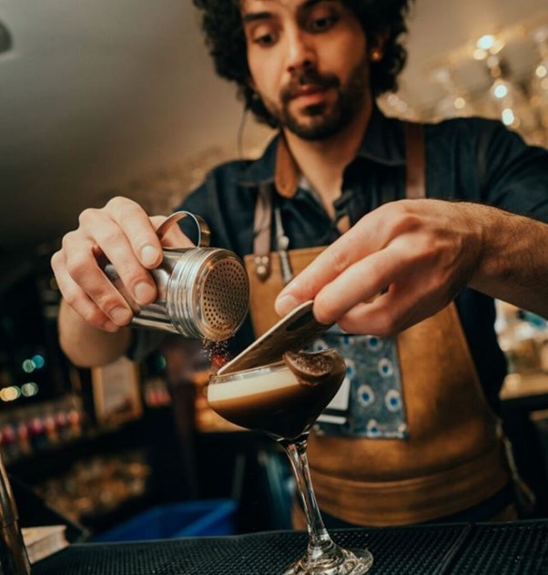 Photograph of bar tender creating a coffee and passion fruit flavoured cocktail