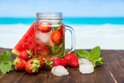 Photograph of strawberry and mint cocktail at the beach