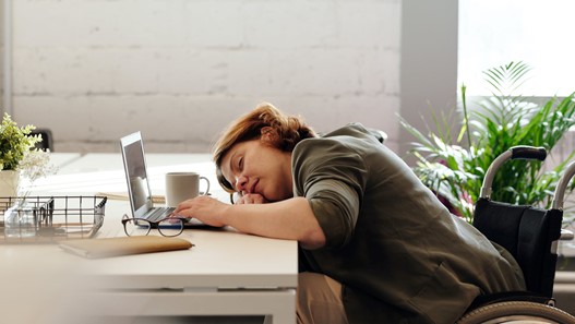 Photograph of woman at her office desk with a hangover