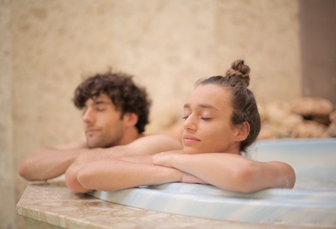 Photograph of young male and female couple in a blue outdoor sauna