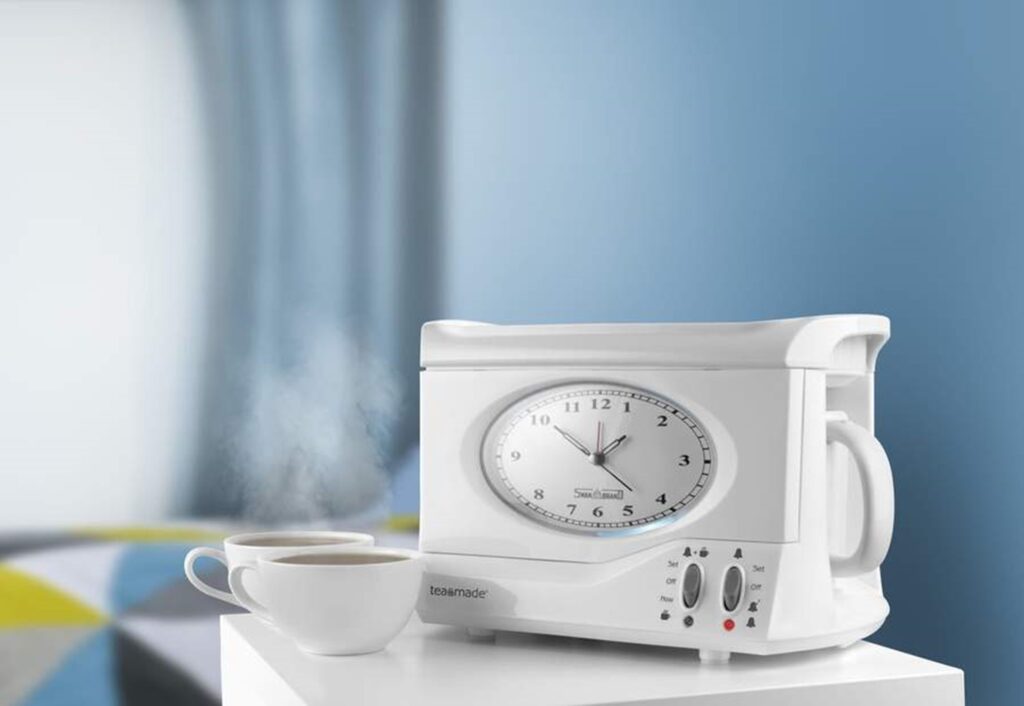 Photograph of the Swan Teasmade on a white bedside cabinet with two white cups of tea