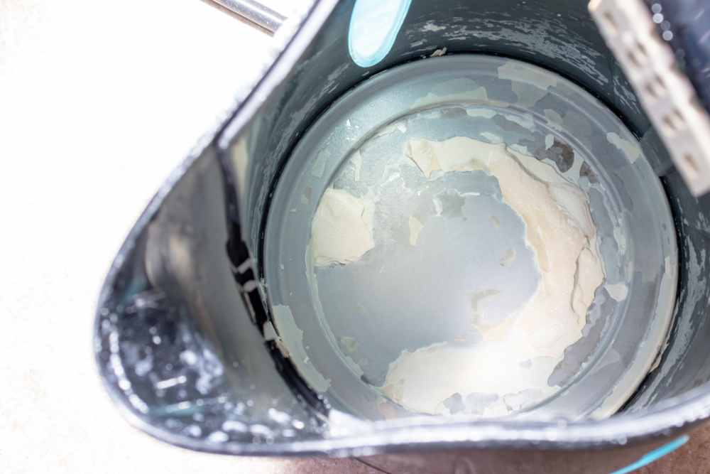 The inside of an empty kettle riddled with limescale. 