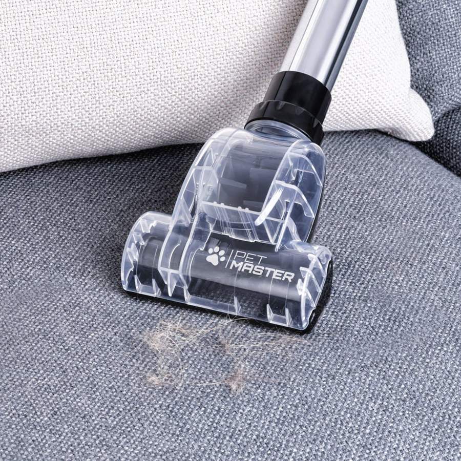 The Swan MultiForce Cylinder Vacuum removing dust from the seat of a couch.