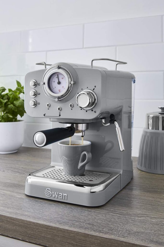A silver Swan espresso machine on top of a wooden table. 