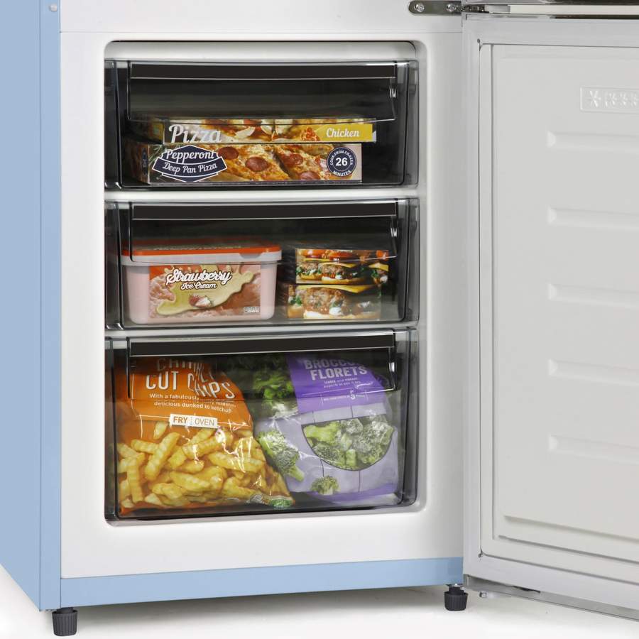 A retro freezer with frozen pizza, ice cream and chips inside the draws.