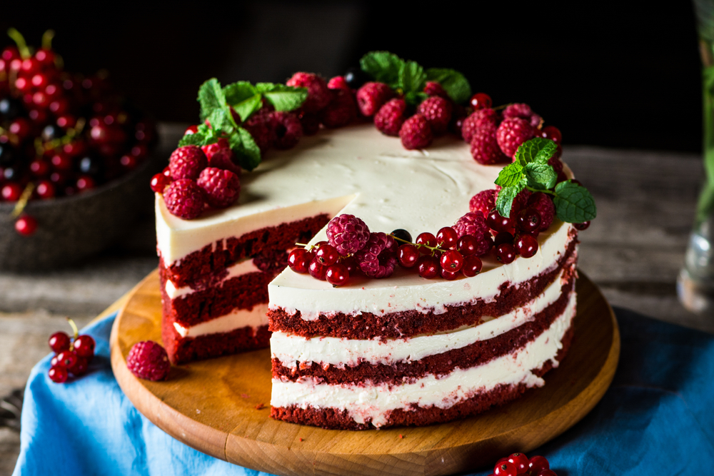 A red velvet cake on a wooden chopping board. 
