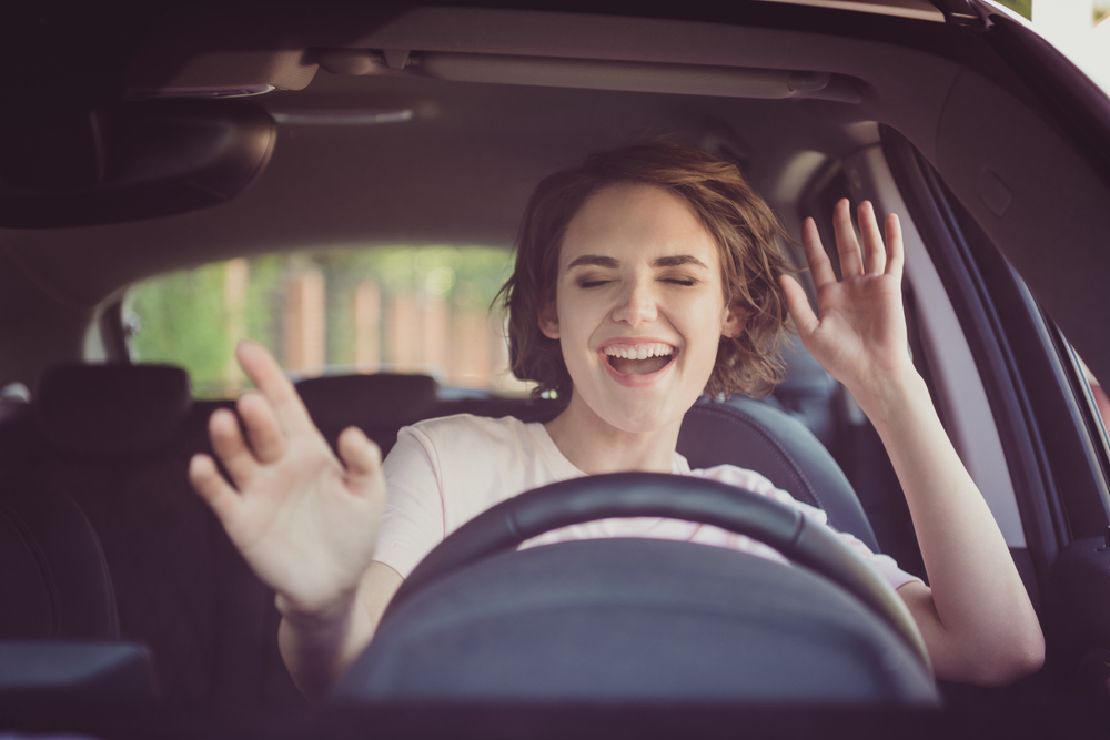 Brunette woman listening to music on her car journey