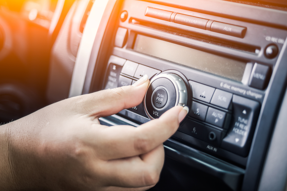 woman turning button off radio in car