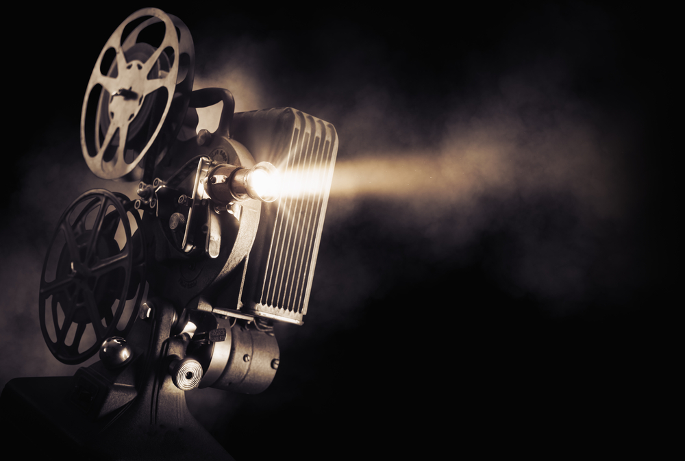Movie projector on a dark background with light beam