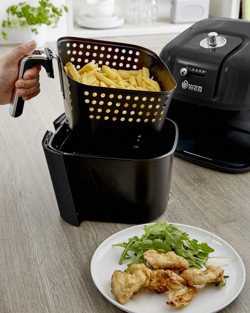 Colour image of a Swan Retro Air Fryer in Black with the basket full of chips 