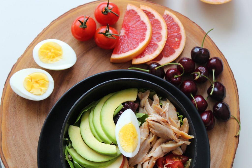 A platter of fruit, veg, and eggs.