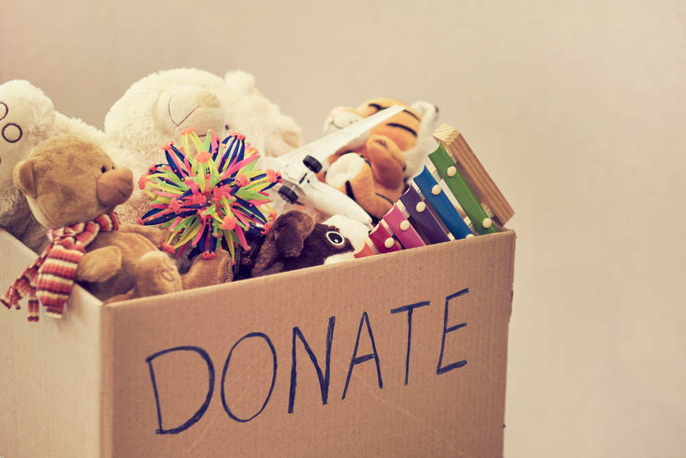 Box of old toys and teddies shows how to spend christmas day donating.