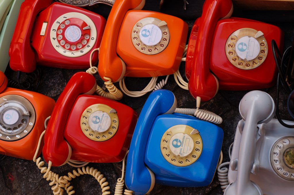 Dial telephones lined up in a row.