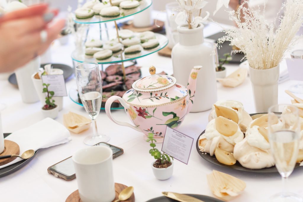 Afternoon tea table place settings with teapots and champagne