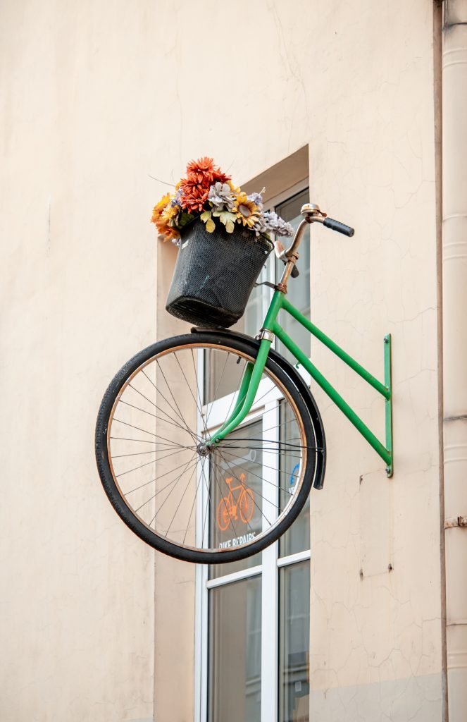 A bicycle recycled into shop wall feature being used as a planter.
